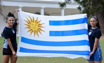 Camila Santos y Sharon López con la bandera de Uruguay y la camiseta de Gimnasia