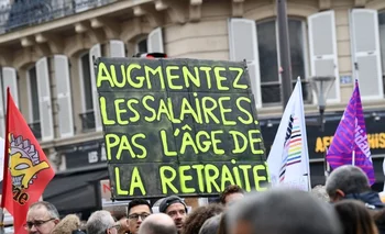 Los manifestantes sostienen una pancarta que dice "Aumentar los salarios, no la edad de jubilación" durante el cuarto día de las manifestaciones contra la reforma de pensiones.