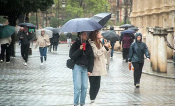 Varias personas se protegen de la lluvia bajo sus paraguas. A 9 de febrero de 2024, en Sevilla (Andalucía, España).