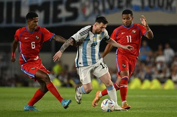 Messi rodeado de dos panameños
