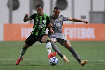 Kevin Méndez pelea el balón con Artur de América Mineiro