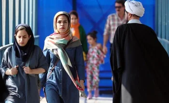 Mujeres iraníes caminan junto a un clérigo en una calle de Teherán en septiembre de 2022.