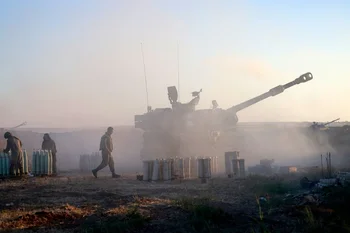 Los soldados israelíes disparan un obús autopropulsado de 155 mm hacia la Franja de Gaza desde su posición a lo largo de la frontera, este 18 de mayo