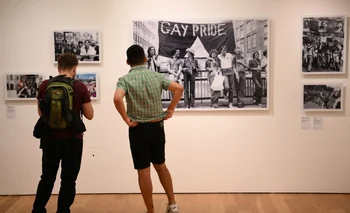 Visitantes miran un conjunto de fotos exhibidas en una galería del museo.