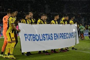 Jugadores de Peñarol con el cartel de la Mutual