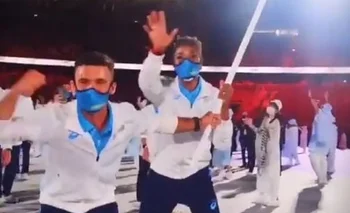 Bruno Cetraro y Déborah Rodríguez con la bandera uruguaya en pleno desfile de la delegación en el Estadio Olímpico
