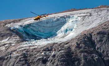Un helicóptero vuela sobre el glaciar que se derrumbó el domingo en la montaña de la Marmolada