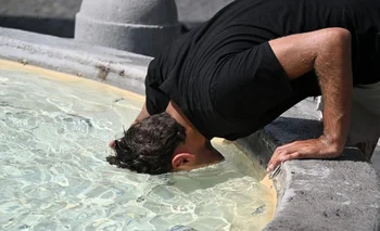 Un hombre se refresca en una fuente romana debido a la ola de calor que invade el hemisferio norte