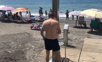 Un hombre en la ducha de una playa de Málaga