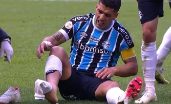  Luis Suárez en el piso y sin la media derecha por la plancha que recibió de André de Fluminense