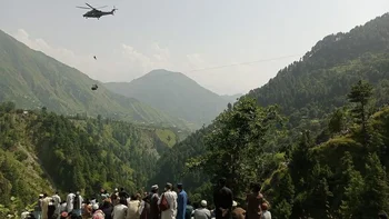 Un soldado del ejército paquistaní intenta descender hasta la cabina desde uno de los helicóteros desplegados para el salvataje