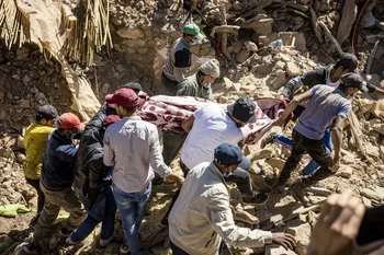 Rescatistas trasladan un cuerpo entre las ruinas de una casa destruida por el terremoto en Marruecos