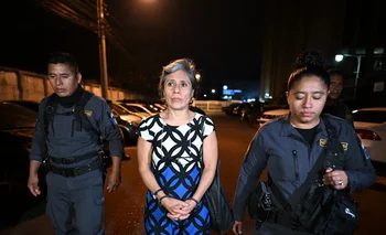 La exfuncionaria de la ONU Claudia González sale de tribunales escoltada por dos policías. 