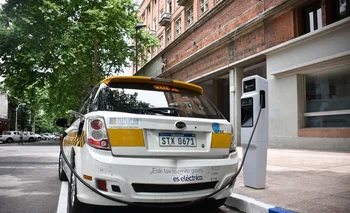 Un taxi eléctrico se carga al lado de la Intendencia de Montevideo.