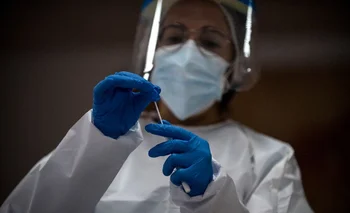 Una trabajadora de la salud sostiene una muestra de hisopo durante una prueba masiva de COVID-19