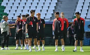 Jugadores coreanos recorren el campo del estadio Education City, en el que debutarán contra Uruguay