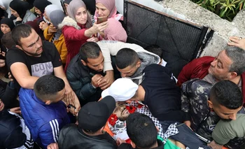 Personas en duelo alrededor de uno de los cuerpos de palestinos asesinados durante los encuentros con las fuerzas armadas de Israel en su pueblo natal de Beit Rima en la ocupada Cisjordania, el 29 de noviembre de 2022