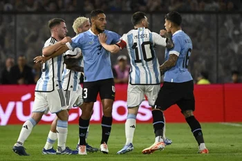 Messi le metió un brazo en el cuello a Olivera; el juez rezongó solo al uruguayo