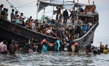 Los refugiados rohinya rechazados por lugareños de una costa de Indonesia retornan al barco para seguir su viaje .