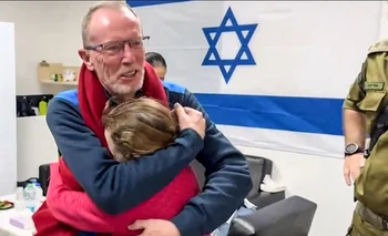 El padre de Emily Hand, de nueve años, se abraza con su hija después de ser liberada en la segunda tanda de canje de rehenes. 