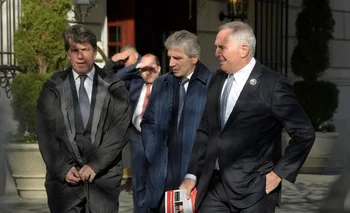 El embajador de Argentina en EE.UU., Mark Stanley (d); y los asesores del presidente electo argentino, Javier Milei, Luis Caputo (c) y Nicolas Posse (i)