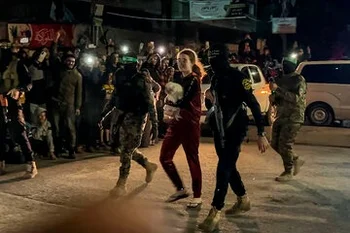 Mia Leimberg camina con su perrita Bella en brazos, escoltada por tropas de Hamás para ser entregada a la Cruz Roja durante el canje de rehenes.