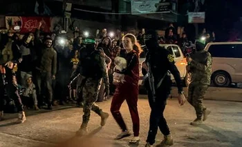 Mia Leimberg camina con su perrita Bella en brazos, escoltada por tropas de Hamás para ser entregada a la Cruz Roja durante el canje de rehenes.
