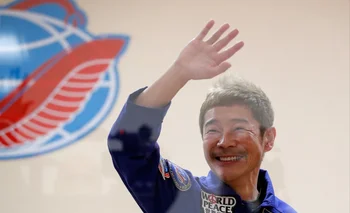 El multimillonario japonés Yusaku Maezawa saluda detrás de una pared de vidrio durante una conferencia de prensa en Baikonur.