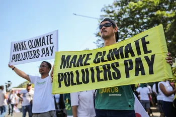 Manifestantes portan pancartas reclamando que los países con mayores emisiones de gases de efecto invernadero aporten fondos para evitar el calentamiento del planeta. 
