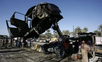 Retiro de los restos del camión bomba que un integrante suicida de EI hizo explotar el domingo 6 en Irak.<br>