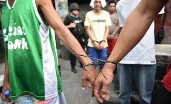 Un agente de la Agencia de Lucha contra las Drogas de Filipinas acompaña a sospechosos en Filipinas