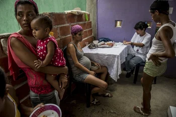 Familias llevan a sus niños a atenderse en una clínica de salud infantil gratuita en Morón. Muchos niños no tienen dónde hacerlo. Fotos Meridith Kohut / The New York Times<br>