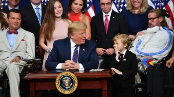 Durante la firma del proyecto de ley en la Casa Blanca, Trump estuvo acompañado por Jordan McLinn, un niño de nueve años que fue diagnosticado con una forma de distrofia muscular terminal y que fue aceptado en un programa clínico en Chicago.