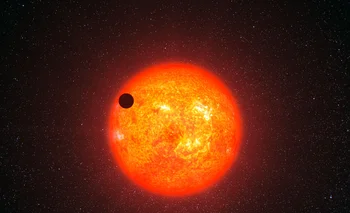 Impresión artística del exoplaneta llamado GJ 1214b, pasando frente a la estrella roja con la que se emparenta
